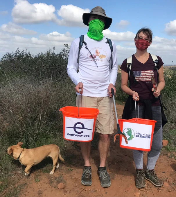 two people standing on dirt with buckets