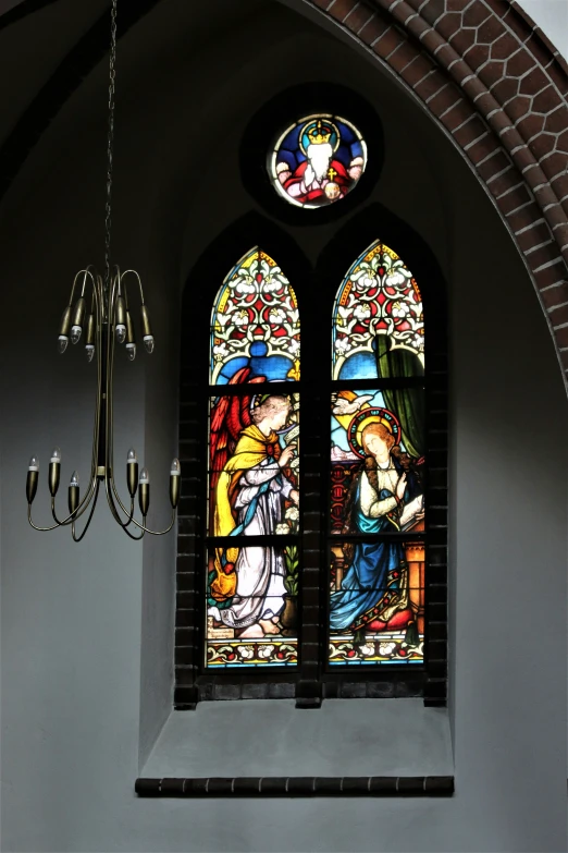 a stained glass window next to an elegant chandelier