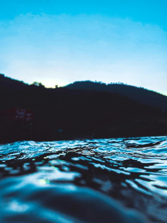 a body of water with hills in the background