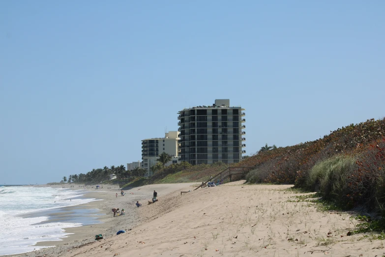 a beach with people walking down it near the water