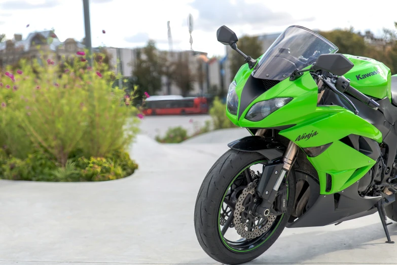 a bright green motor cycle is parked next to some bushes