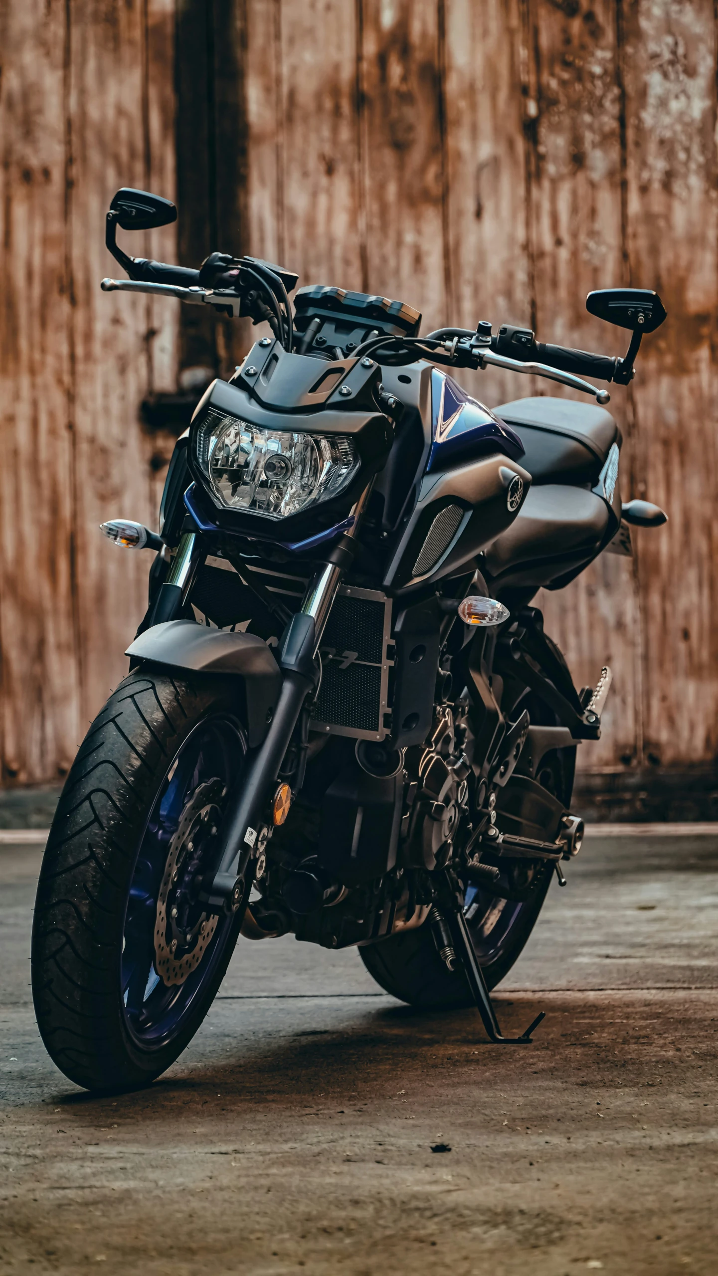 the motorcycle is parked by the wall of wood