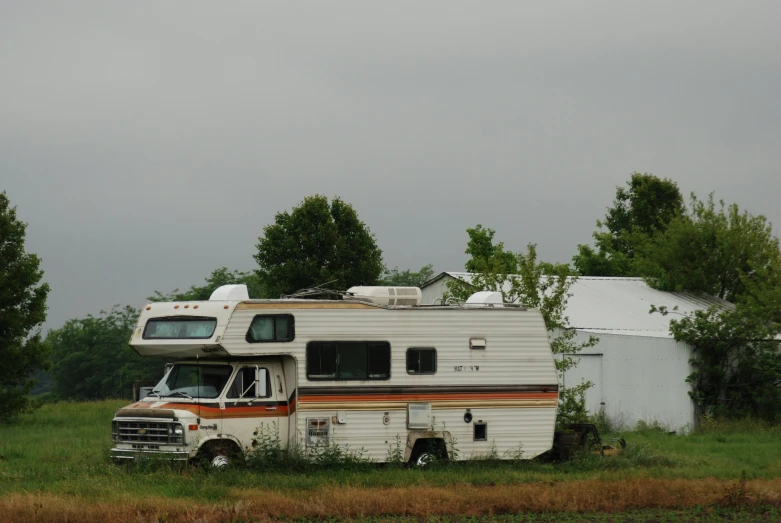 a truck parked in front of a white house in the field