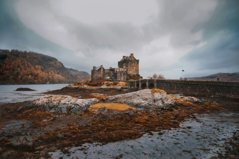 an abandoned castle by the water on a mountain