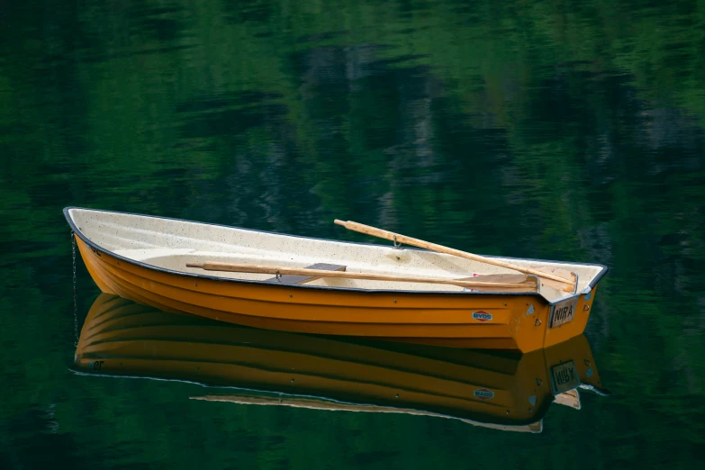 a yellow boat floating on top of a lake