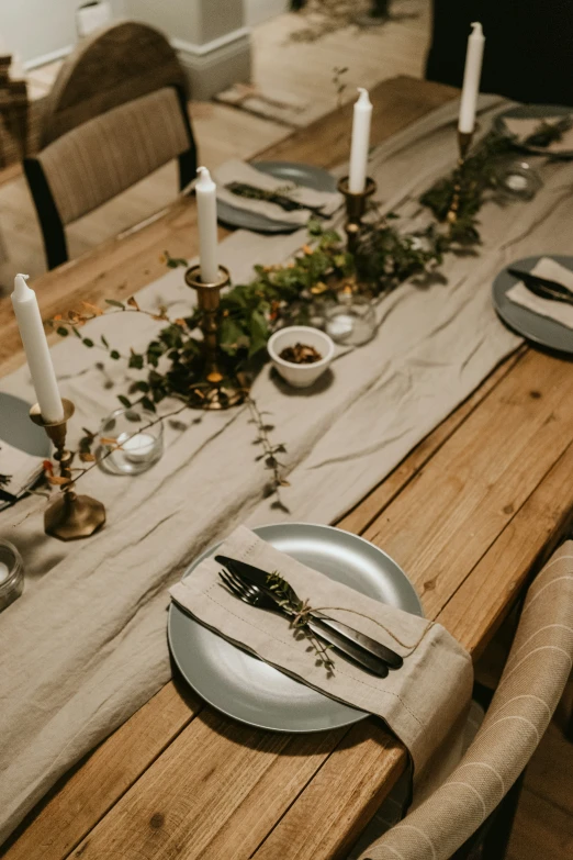 a table with place settings, candles and plates