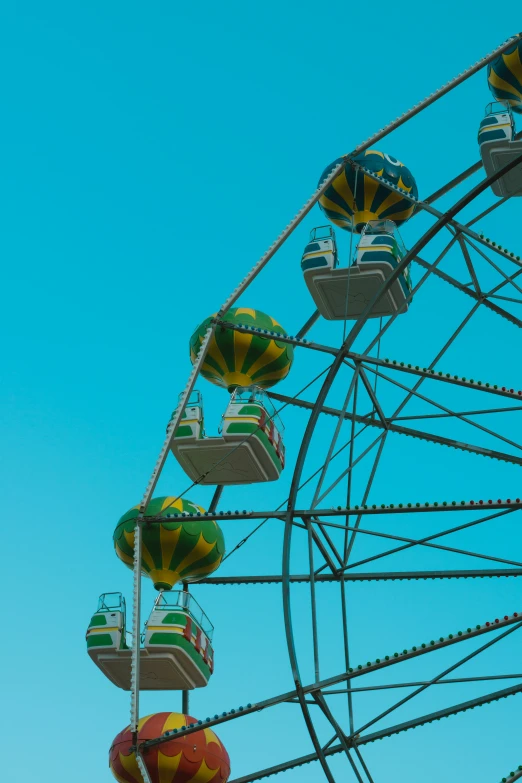 a ferris wheel with several colorful carnival floats below