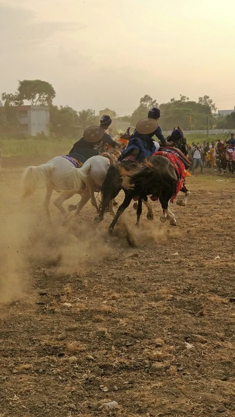 men herding a team of horses in a dusty field