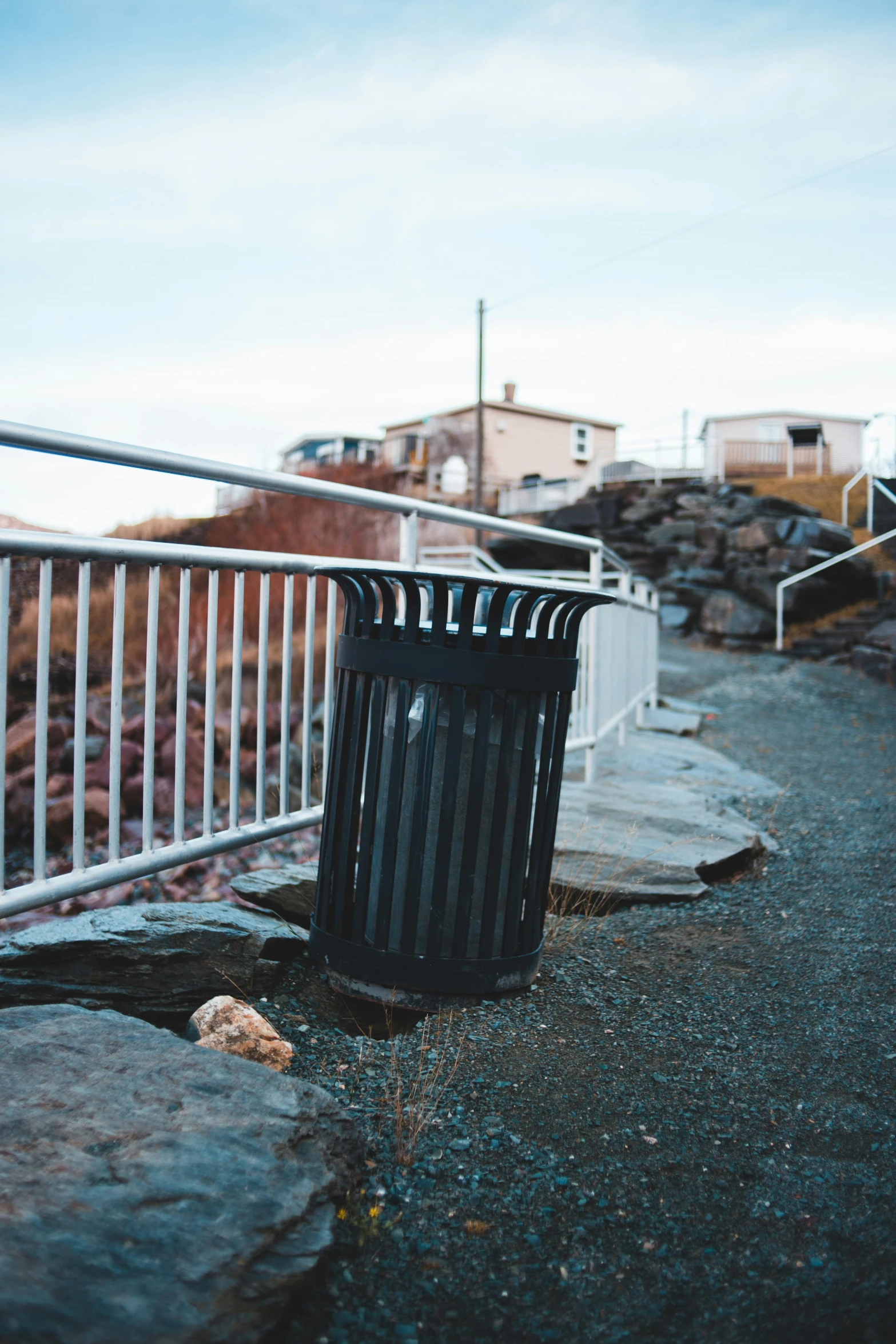 a garbage can sitting on the side of a road