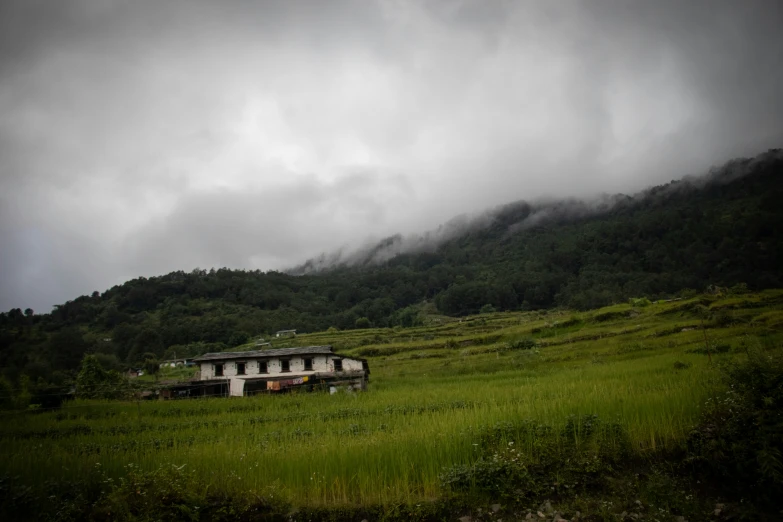 clouds fill the sky over some buildings on a hill