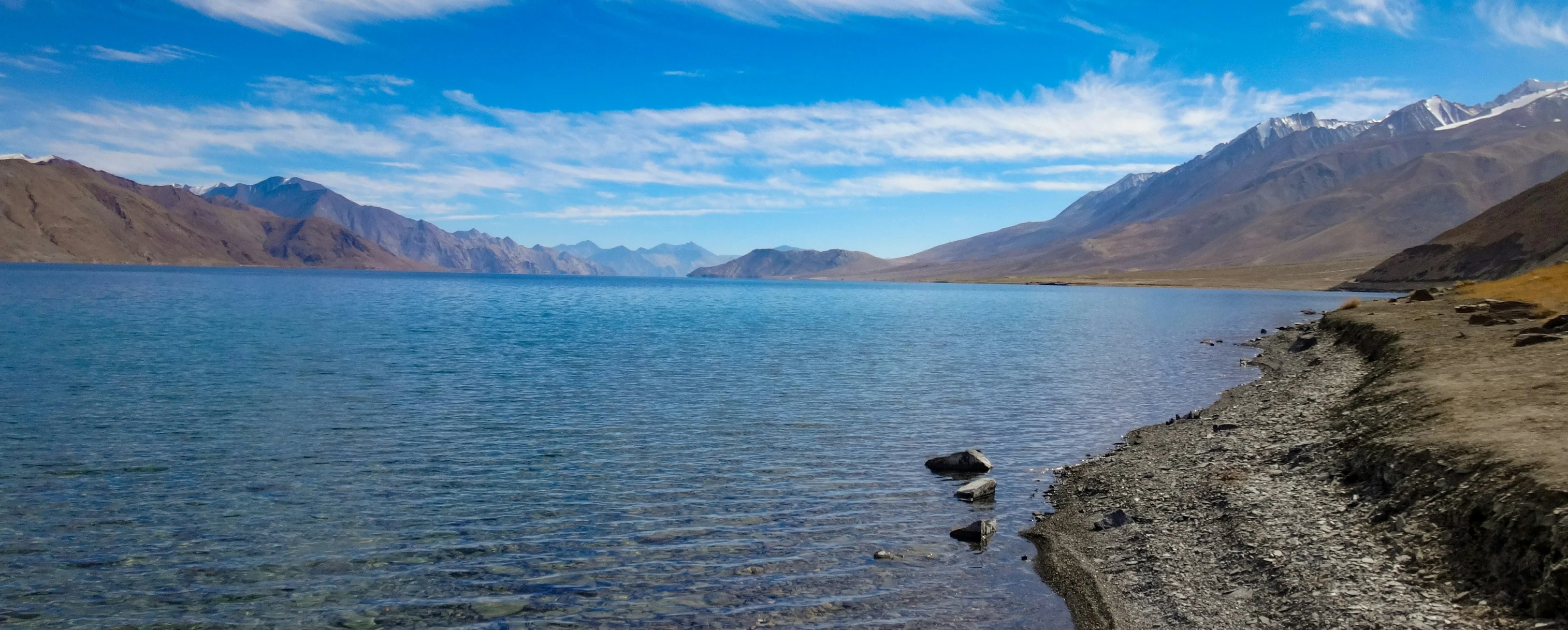 a person walking along the edge of a large body of water