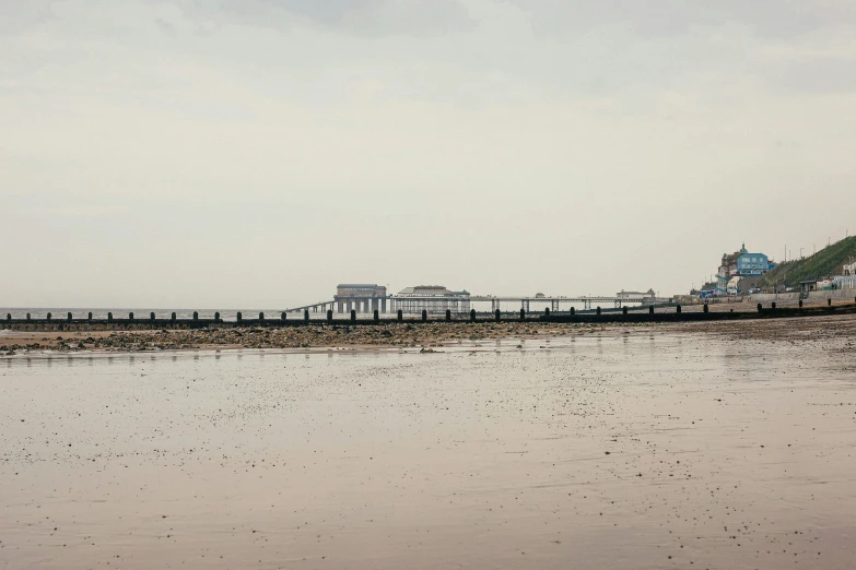 a pier near the ocean in the sand