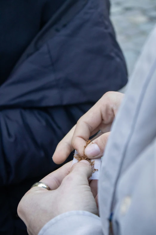 a person is taking a cigarette out with another person's hand