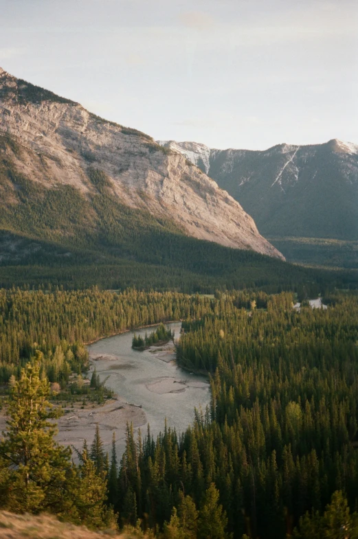 a view of the mountains and trees and a small river