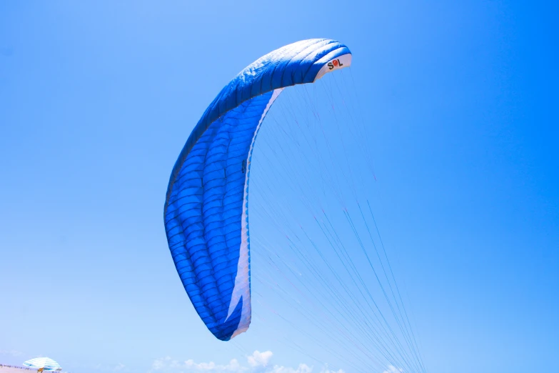 the parasailer is riding the wind over the beach