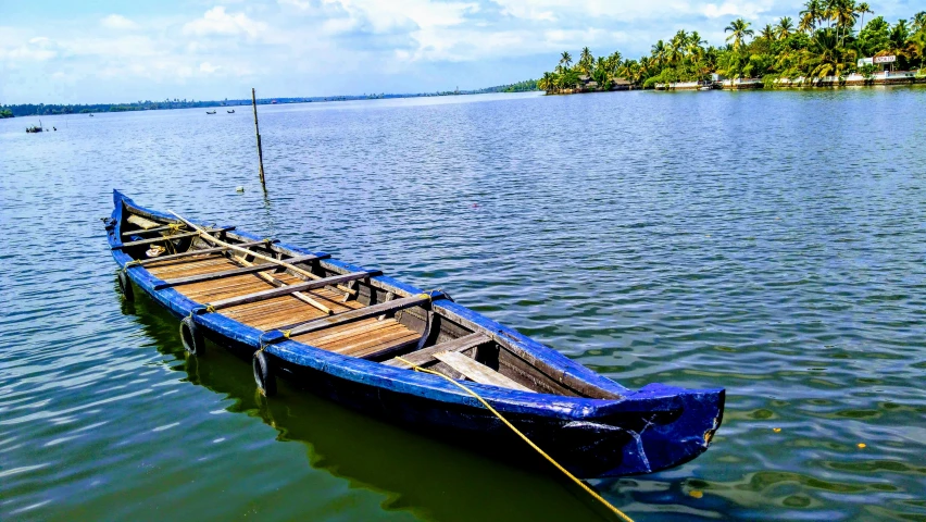 the blue boat is in the water with a rope