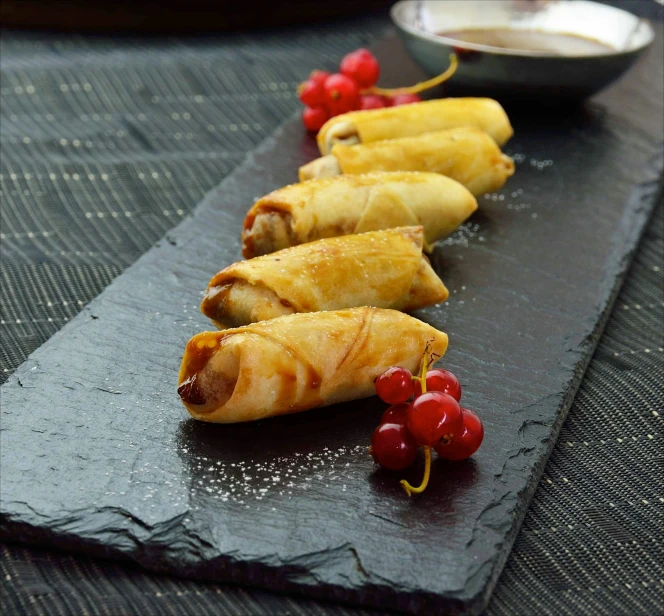 four long appetizers with different kinds of fruit on them