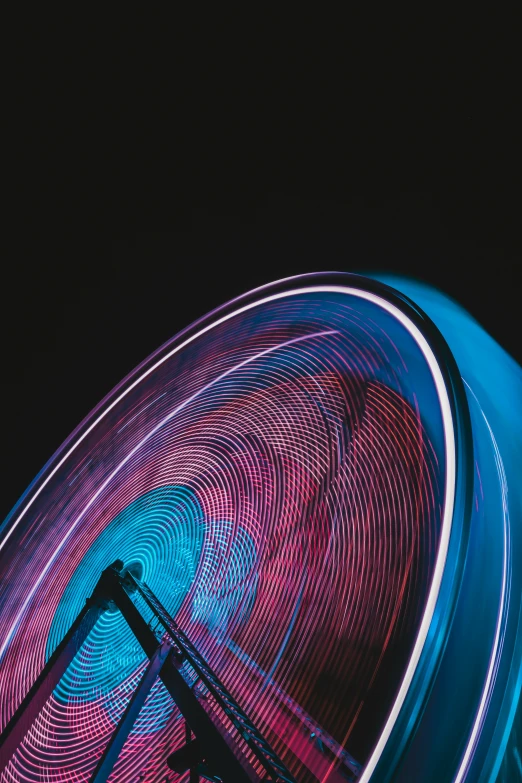 a big spinning wheel is illuminated with blue and red lights