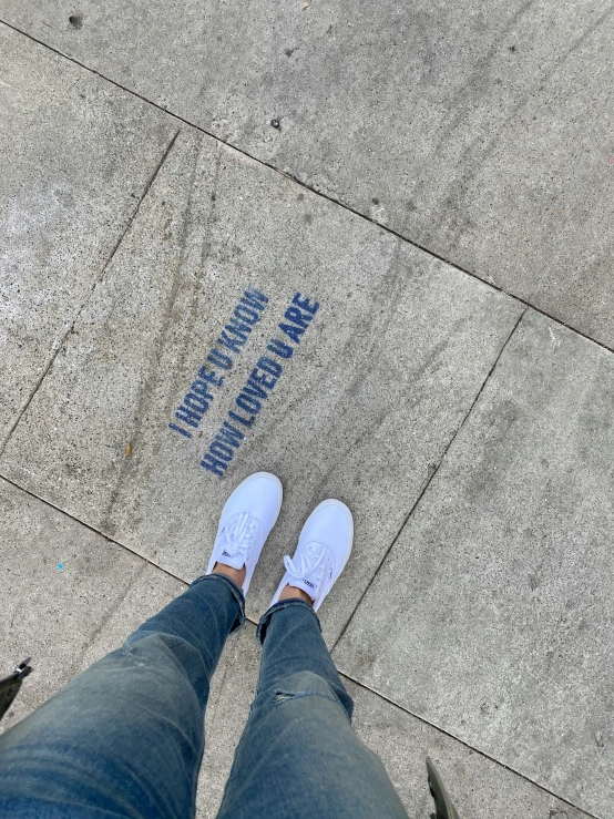 a person standing on the sidewalk with his feet up