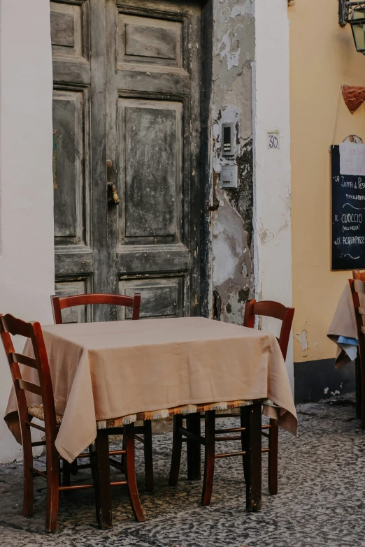 a couple of wooden chairs next to a table