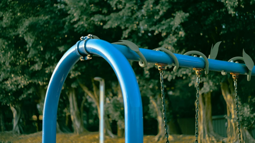 blue playground equipment, including an empty swing set and chains