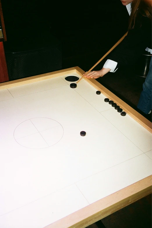 a lady playing air hockey in a small room