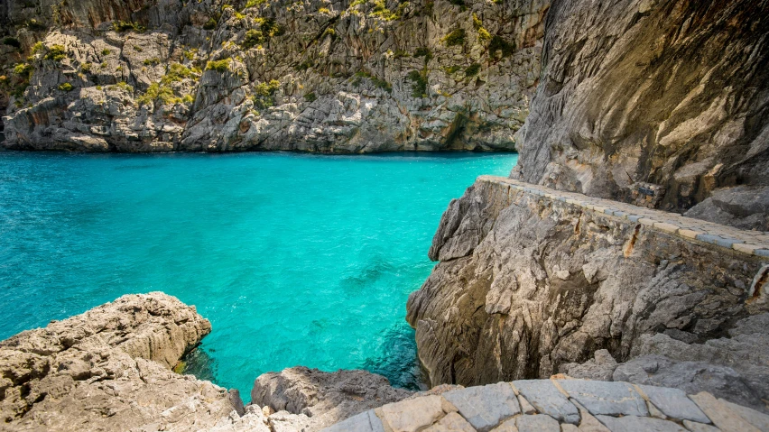 a small body of water surrounded by a rocky cliff