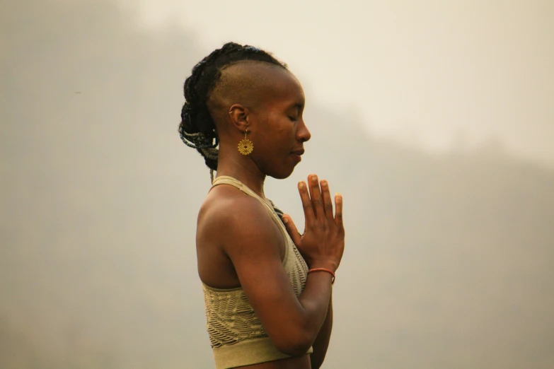 a woman who is standing with her hands together