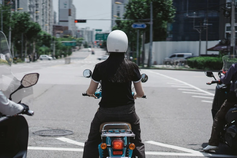 woman riding a scooter with a full helmet on