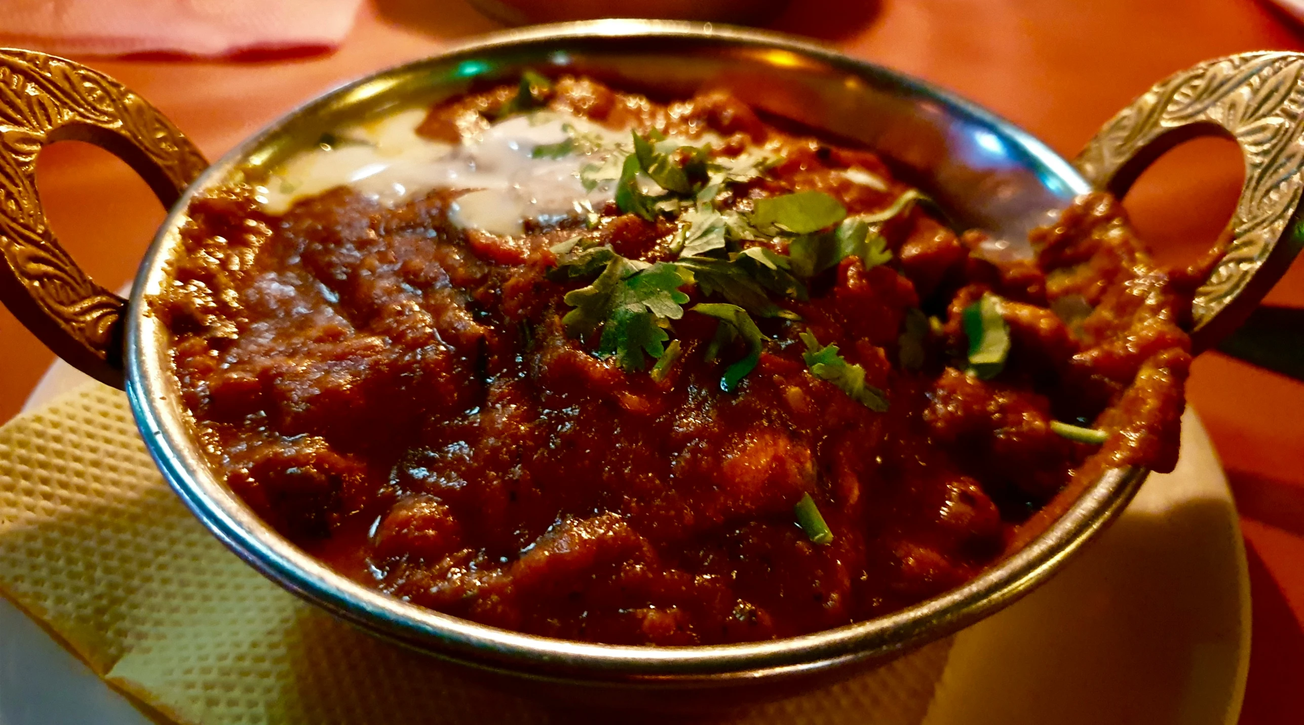 a silver bowl of food that is on a table