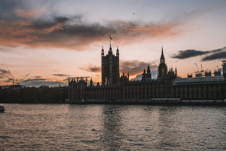 a sunset over the water with a clock tower