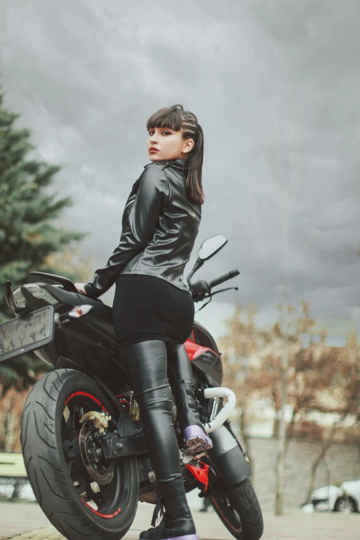a young woman is sitting on top of her motorcycle