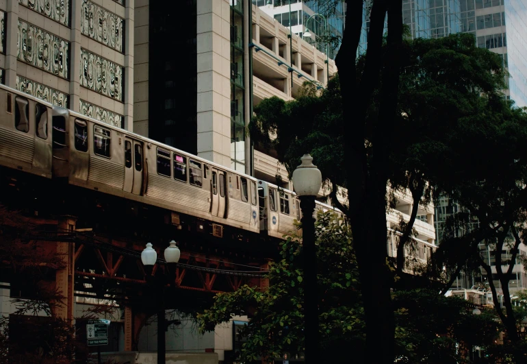 an elevated commuter train driving through a city