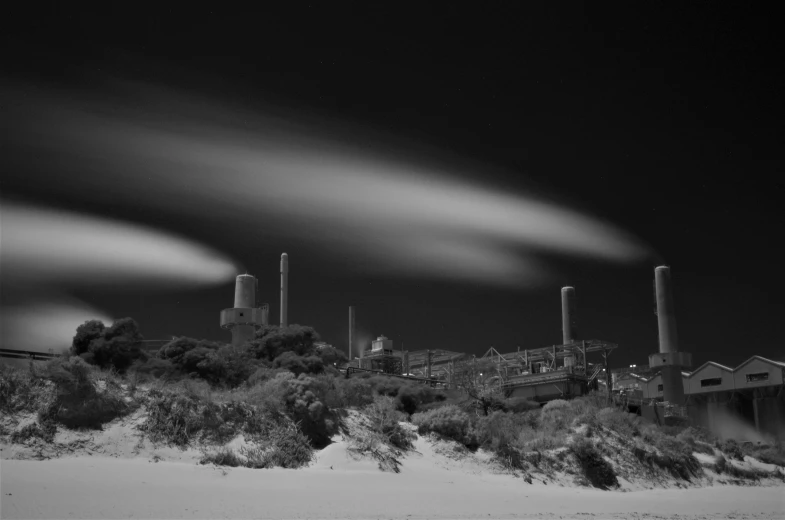 black and white image of smoke stacks above a field