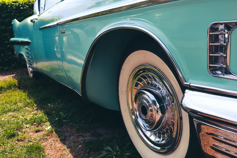 an old car with a reflection in the wheels