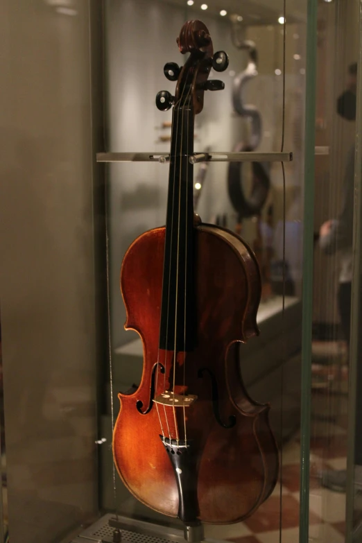 a violin in a glass case with another violin