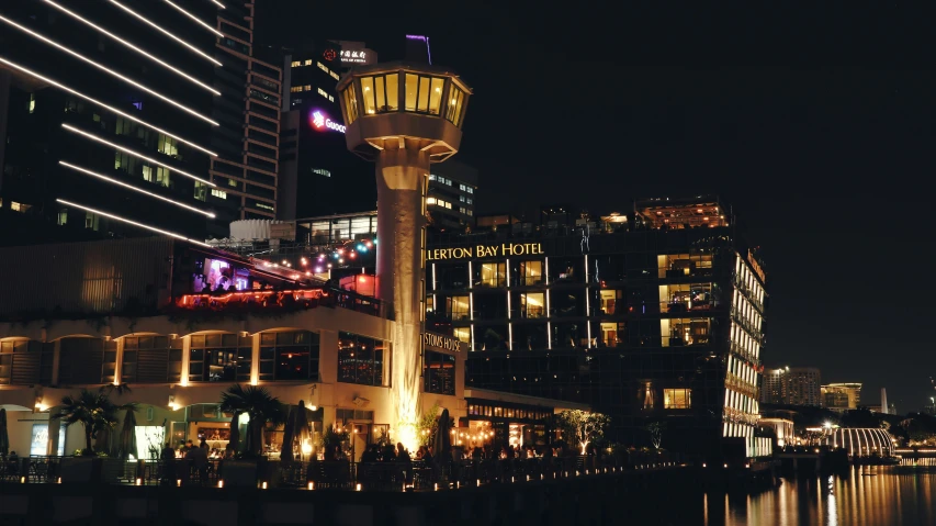 the water is at night near skyscrs and buildings