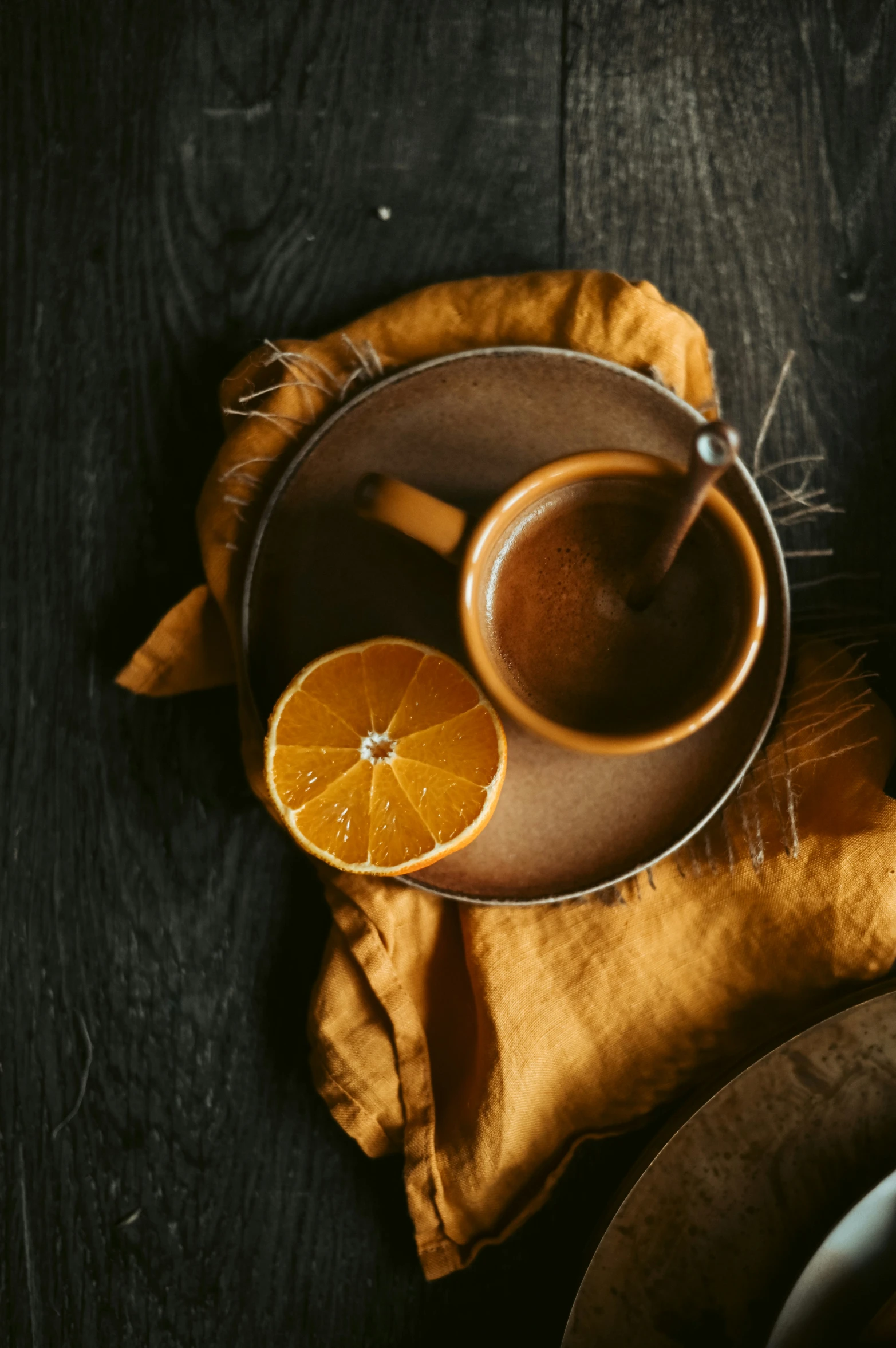 a plate with an orange and two cinnamon slices sitting on it