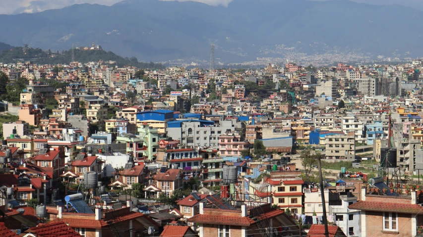 some buildings with brown roofs are surrounded by hills