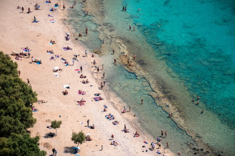 an overhead s of a crowded beach and the sea