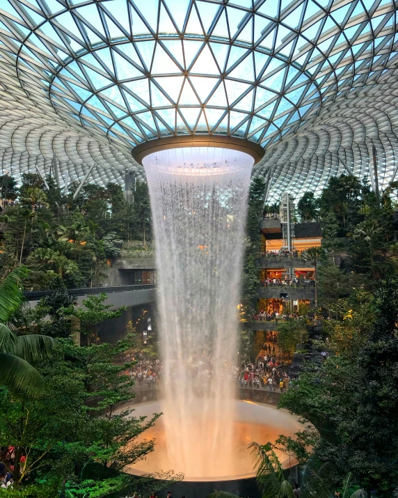 people standing under the water fall in a tropical setting