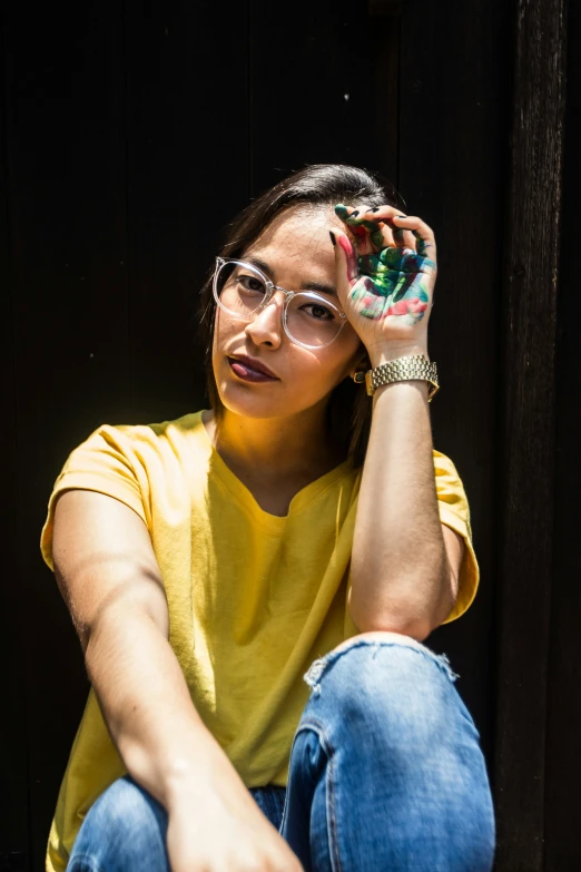 a woman is sitting in front of the door with her hands on the forehead