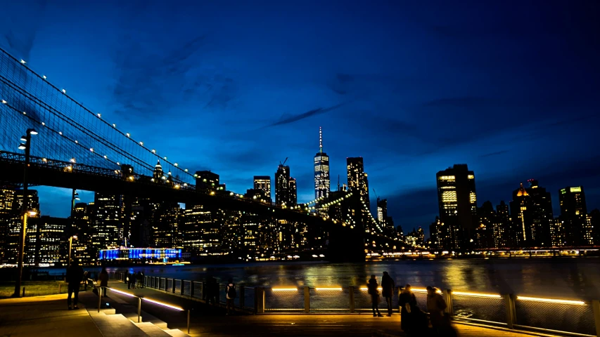 a city at night with lights in the foreground and water below