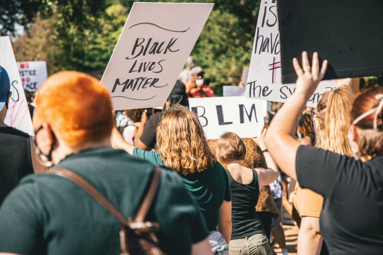 a group of people marching with white signs