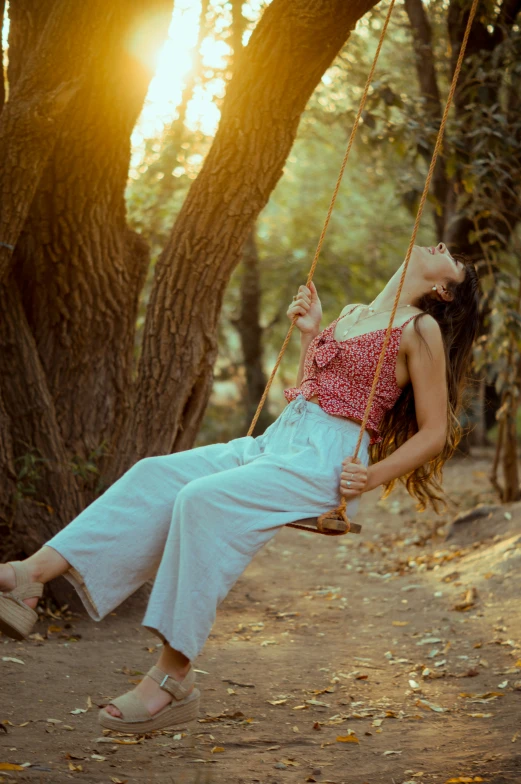 a woman sitting in the air on a swing