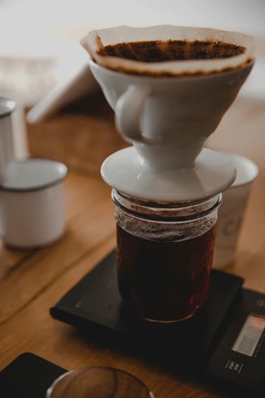 a white coffee pot with liquid over it