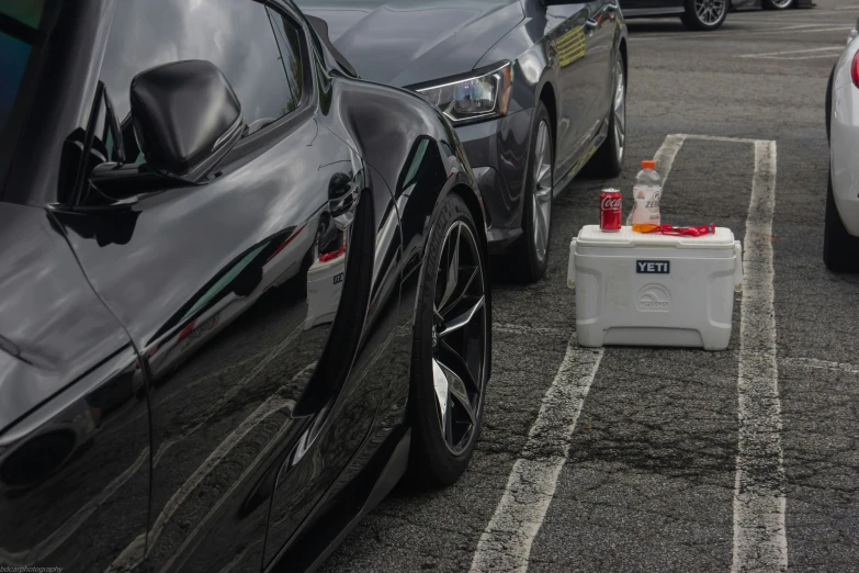 car with fuel in a white cooler and others in parking lot