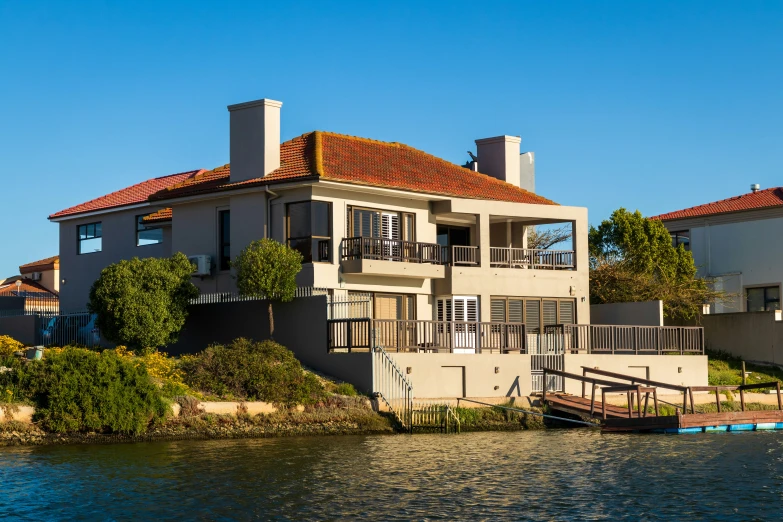 an image of two houses with boats passing by