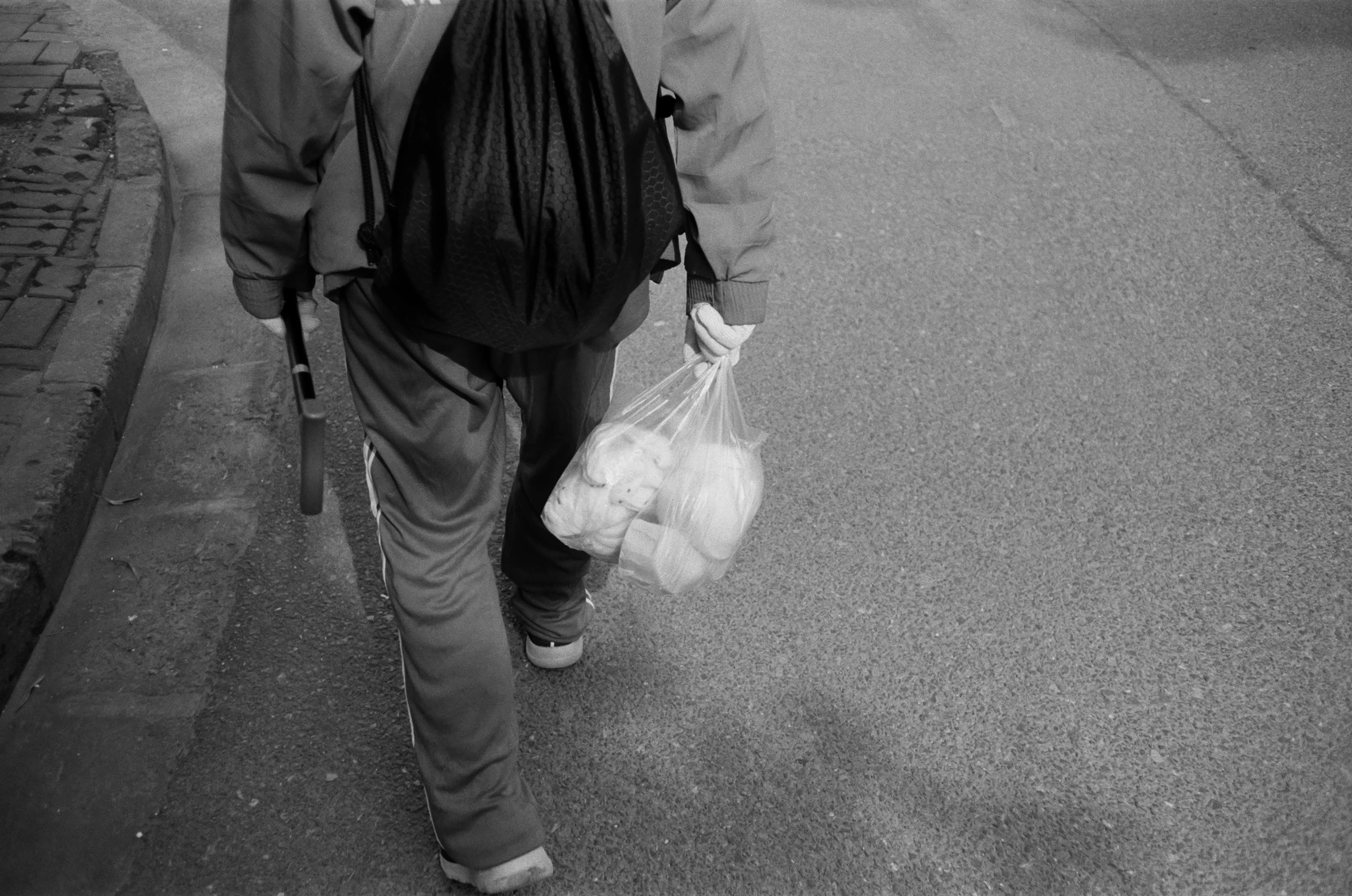 a person walking down a street carrying a bag