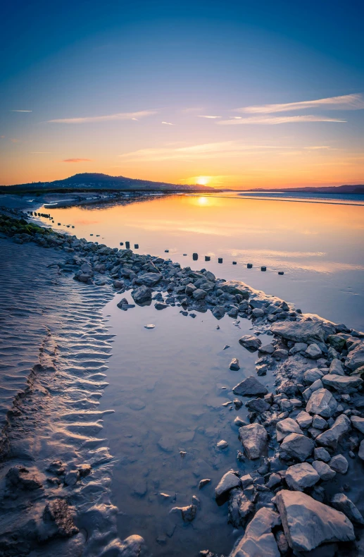 the sun rises over water that reflects its surface